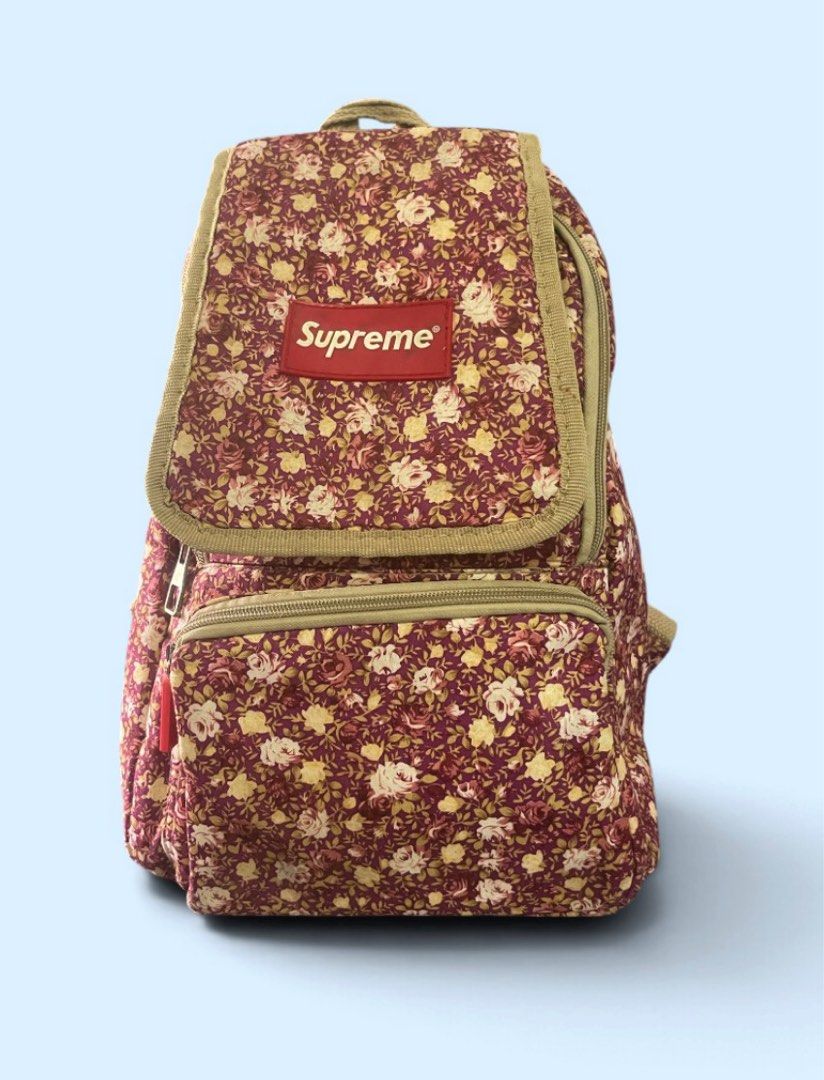 Supreme Floral Backpack Burgundy Canvas OFF (Category: Backpacks) located in San Pedro. Submitted by lifebeginsaftercoff33 (Listing ID 1468737711, Image 2). Description: - Brand: Supreme - Color/Design: Burgundy with all-over floral print and tan canvas trim - Condition: Clean fabric inside and out, sturdy construction - Features: Front zipper pocket, flap closure with red Supreme logo patch, adjustable shoulder straps - Perfect for: Streetwear, 