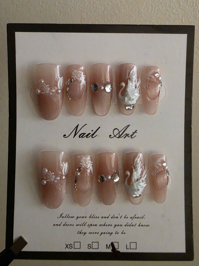 Swan Nail Art Press-on Nails [M size] (Category: Hands & Nails) located in Cavite. Submitted by phoibee (Listing ID 1468785961, Image 2). Description: - Handmade press-on nail art - Nude pink base with shimmering cat's eye effect and floral patterns - Decorated with detailed 3D white swan charms, pearls, and rhinestones - Size: Medium - Reusable and ready to apply *if you have questions, feel free to ask. .