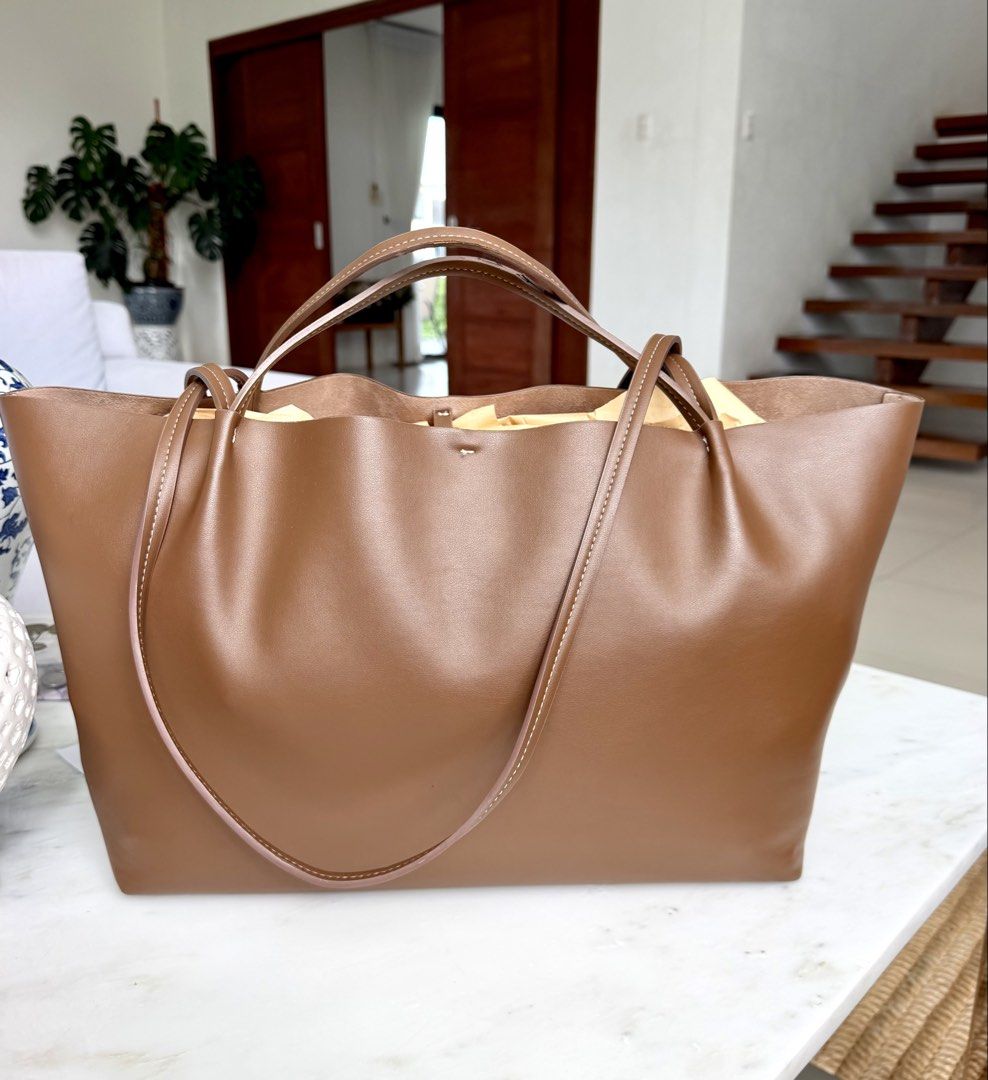 Zara Tan Tote Bag (Category: Tote Bags) located in Lipa City. Submitted by pauline0303 (Listing ID 1468715999, Image 1). Description: - Color: Classic brown - Material: Premium soft leather with soft interior lining - Design: Minimalist style with contrast white stitching on handles and base - Structure: Spacious open interior with a rectangular base to hold its shape - Versatility: Dual shoulder straps for shoulder and arm, perfect for daily wea