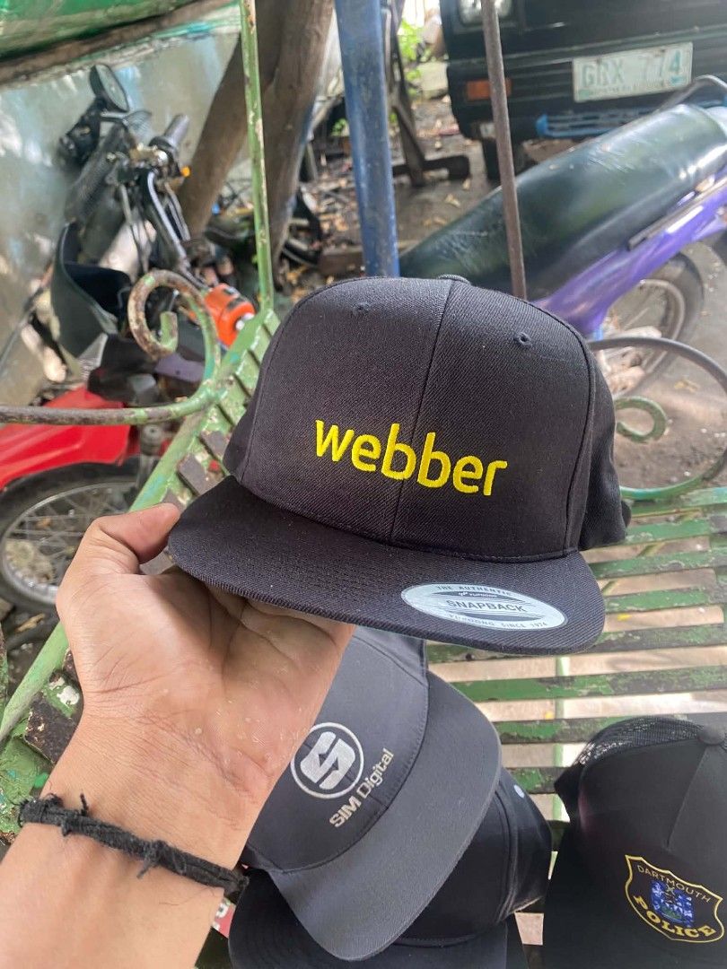The Classics Yupoong Snapback Cap Webber Yellow Text Black (Category: Caps & Hats) located in Sibulan. Submitted by thethiftedcap0728 (Listing ID 1468734951, Image 1). Description: - Brand: The Classics Yupoong - Style: Classic flat brim snapback cap with green underbrim - Design: Eye-catching bright yellow "webber" embroidery on the front - Material: 80% acrylic, 20% wool blend (Made in Bangladesh) - Closure: Adjustable plastic snapback for a cu