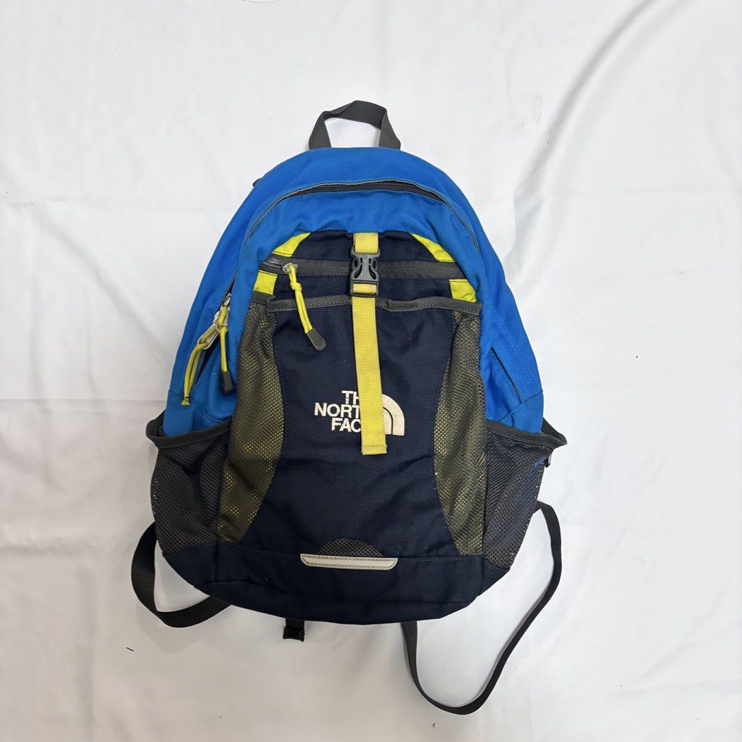 The North Face Small Youth Backpack (Category: Backpacks) located in Imus. Submitted by wear.arca (Listing ID 1468825316, Image 1). Description: - Brand: The North Face - Can fit iPad, water bottle - Flaws: Slight thinning on base fabric, loose garter of side pockets - Body is still good! - Colorway: Blue, Navy, and Yellow - Storage: Main compartment with inner divider, front zipper pocket, and dual mesh side pockets for water bottles - Comfort: 