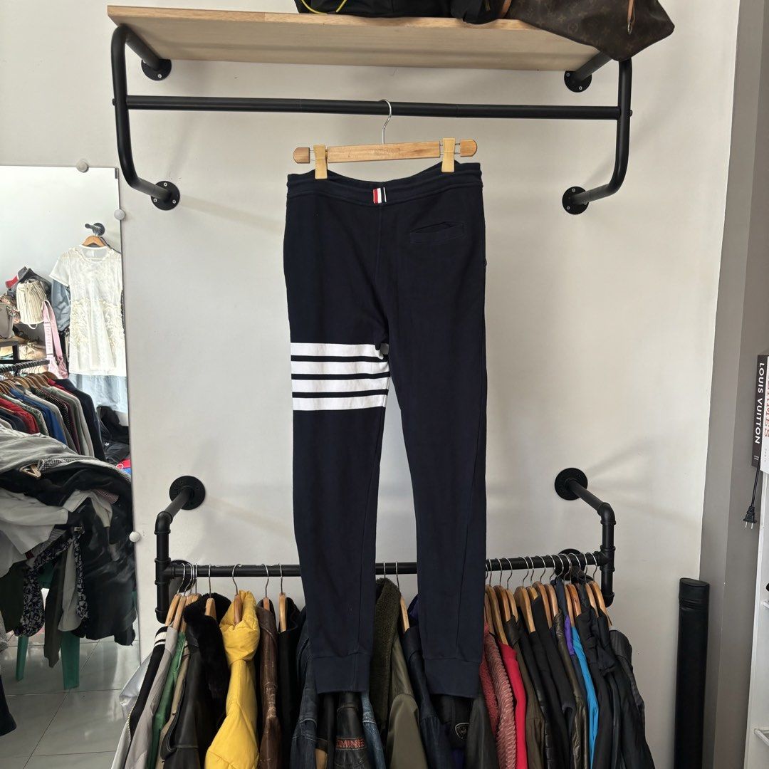 Thom Browne Navy 4-Bar Sweatpants Size 1 (Category: Joggers) located in Bambang. Submitted by heats777 (Listing ID 1468820887, Image 3). Description: - Brand: Thom Browne - Color: Navy - Signature white 4-bar stripes on the left leg - Adjustable drawstring waist with gold-tone aglets - Ribbed cuffs and woven size tag near the hem - Single back pocket with tricolor tab detail - Condition: 100% authentic and well-maintained - Mode of Payment: BPI /