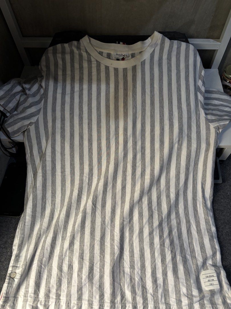 Thom Browne striped t-shirt size 2 (Category: Tshirts & Polo Shirts ) located in San Leonardo. Submitted by flipdrex (Listing ID 1468924116, Image 1). Description: - Brand: Thom Browne - Color: Grey and white striped - Size: Tagged Size 2 - Style: Crew neck, short sleeves - Material: Lightweight cotton - Details: Signature brand tag inside collar and size tag at bottom hem - Condition: Excellent / Pre-loved (ready to wear) - Mode of Payment: GCas
