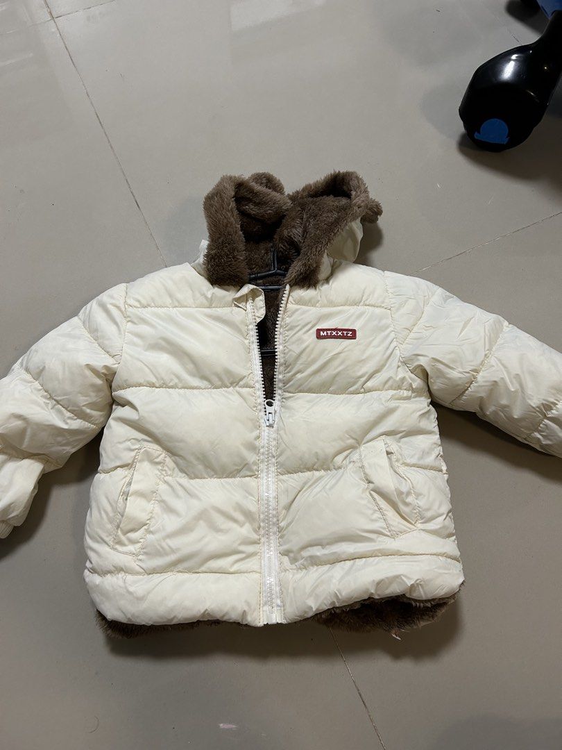Toddler Puffer Jacket With Bear Ears (Category: Babies & Kids Fashion) located in Antipolo. Submitted by mommytj (Listing ID 1468741577, Image 3). Description: - Size: Toddler - Color: Off-white with brown furry lining - Features: Cute bear ears on hood, front zipper closure, two side pockets, and small red MTXXTZ chest patch - Condition: Worn once during our hongkong vacation, super cozy and warm - Perfect for cold weather and winter travels!.