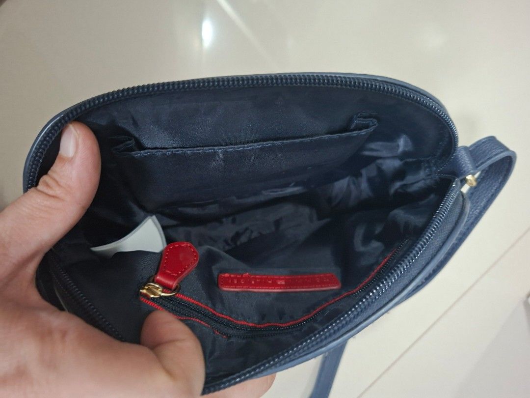 Tommy Hilfiger Monogram Blue Crossbody Bag (Category: Cross-body Bags) located in Muntinlupa City. Submitted by ladybossgemini (Listing ID 1468865646, Image 3). Description: - Authentic Tommy Hilfiger crossbody bag in stylish blue monogram shades - 8.5/10 condition - Adjustable shoulder strap with convenient lobster clasps - Dark fabric-lined interior with 1 zippered pocket (featuring a red pull tab) and 1 open slip pocket - clean inside -fits es