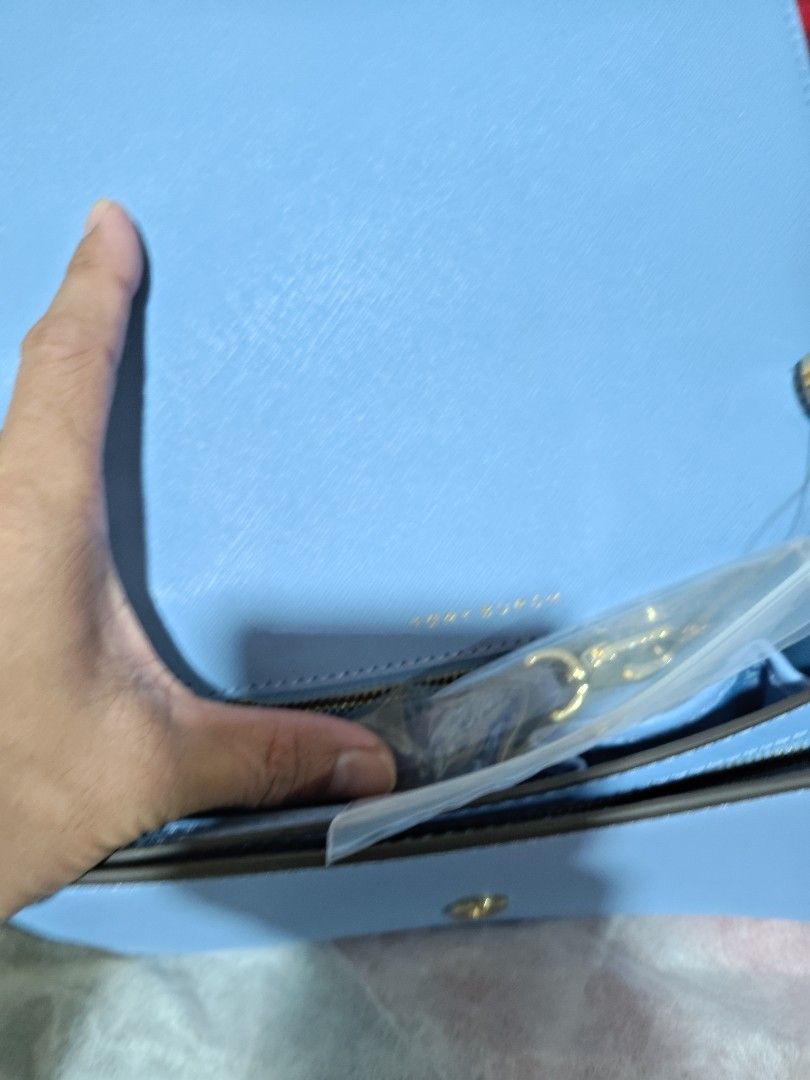 Tory Burch Blue Crossbody Bag with Strap (Category: Cross-body Bags) located in Valenzuela. Submitted by wisewhale_46982b (Listing ID 1468779363, Image 2). Description: - Brand: Tory Burch Crossbody Bag - Color: Light Blue with Gold-tone Hardware - Material: Durable Saffiano Leather - Inclusions: Detachable shoulder strap (brand new in plastic wrapper) - Condition: Clean interior, structured shape, with a minor wear mark on the side edge near the
