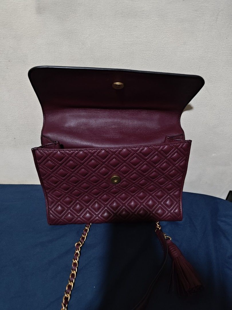 Tory Burch Burgundy Fleming Quilted Leather Shoulder Bag (Category: Luxury Bags & Wallets) located in Valenzuela. Submitted by wisewhale_46982b (Listing ID 1468768983, Image 3). Description: - Brand: Tory Burch - Color: Rich Burgundy - Material: Quilted leather body with smooth leather flap - Hardware: Gold-tone chain strap with leather shoulder guard - Details: Embossed T logo, matching tassel charm, and magnetic flap closure - Interior: Clean l