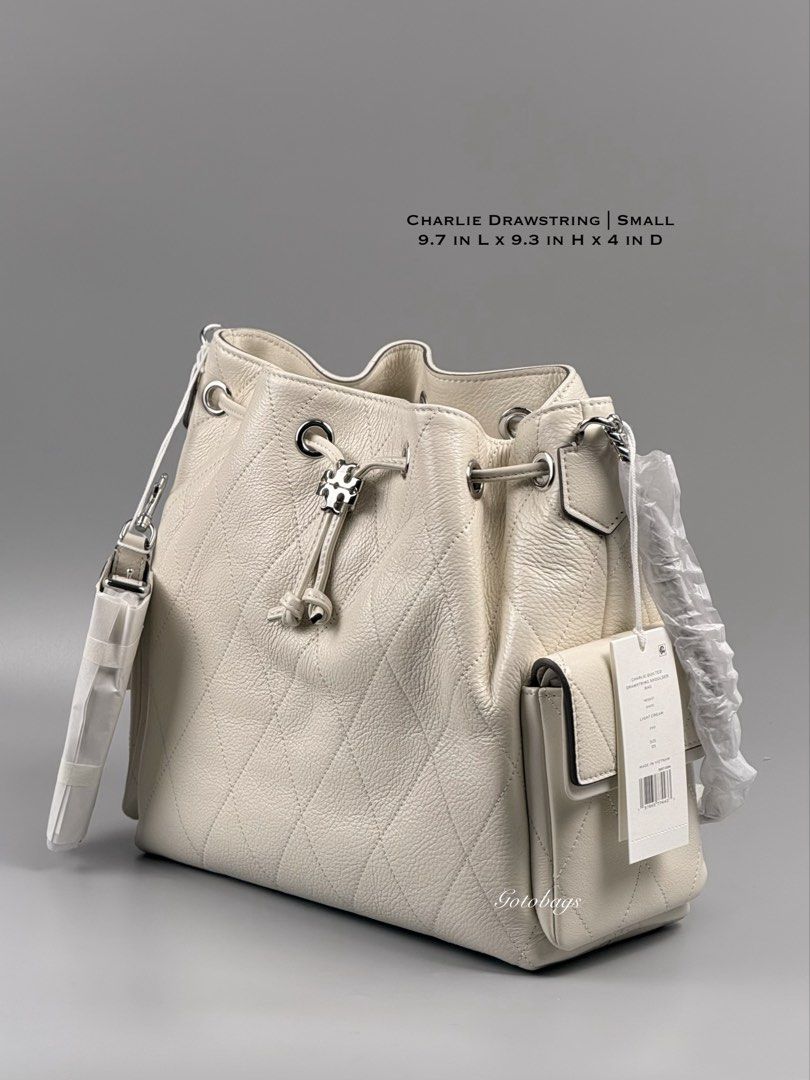 Tory Burch Charlie Quilted Drawstring Shoulder Bag Light Cream (Category: Shoulder Bags) located in Angeles City. Submitted by gobagsto (Listing ID 1468738805, Image 1). Description: - Brand: Tory Burch Charlie - Style: Quilted drawstring shoulder bag - Color: Light cream with silver-tone hardware - Features: Iconic logo toggle, dual side pockets with flap closures, and chain strap detail - Condition: Brand new with original tags attached and pro