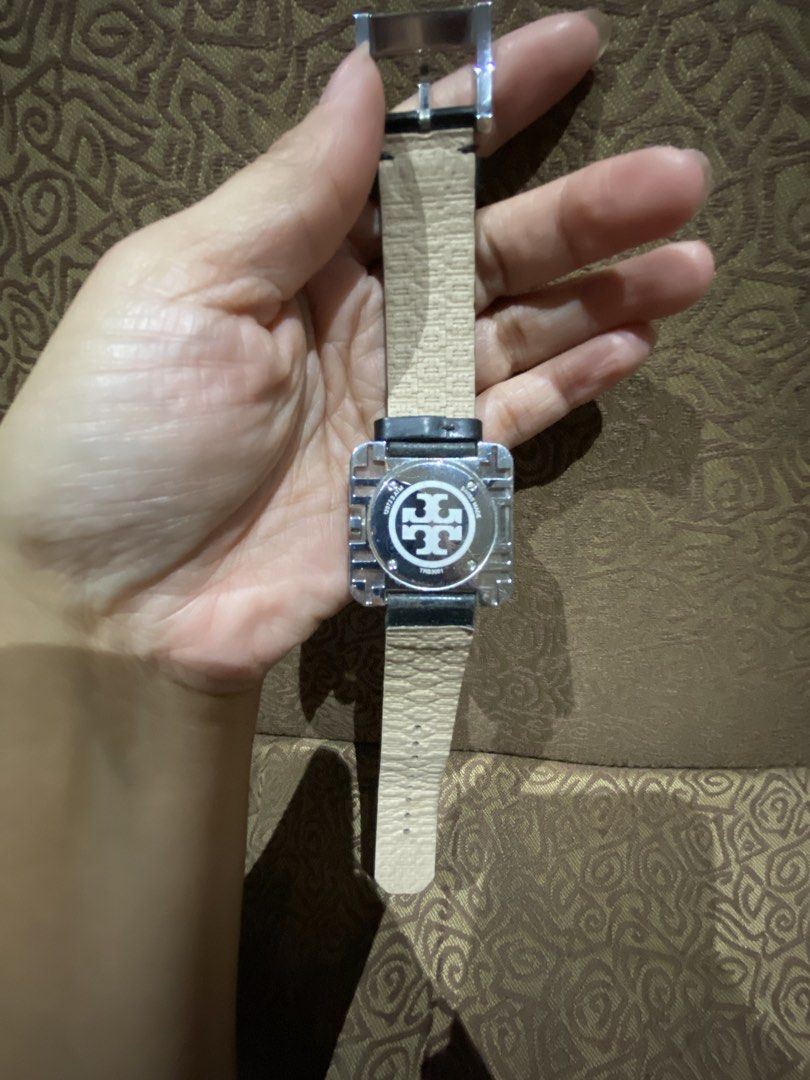 Tory Burch Square Izzie Square Lucite (Category: Women's Watches) located in Quezon City. Submitted by mjgaudier (Listing ID 1468866048, Image 2). Description: - Brand: Tory Burch - Design: Geometric square clear crystal casing with a round black dial - Strap: Genuine black leather with buckle closure and engraved logo hardware - Movement: Swiss made, battery-operated quartz - Inclusions: Original orange Tory Burch presentation box and packaging 
