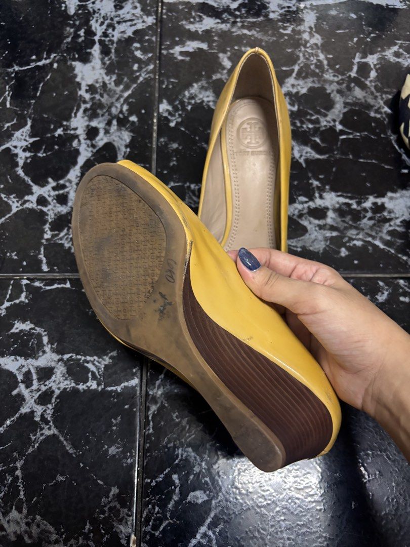 Tory Burch Yellow Open-Toe Wedge Heels (Category: Wedges) located in Manila. Submitted by urthrifthany (Listing ID 1468724652, Image 3). Description: - Brand: Tory Burch - Style: Open-toe wedges with wooden heel - Color: Bright yellow with pale pink logo emblem - Material: Patent finish with leather lining and branded footbed - Fit: Comfortable height, great for daily outfits - Condition: Some wear on soles and minor scuffs near the heel area.
