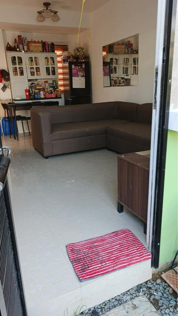 Townhouse for Rent (Category: House & Lot) located in Manila. Submitted by rianarciso60352 (Listing ID 1468715523, Image 3). Description: - Multi-story townhouse unit - Living area with brown L-shaped sofa - Dining space and kitchen cabinets included - Multiple bedrooms with beds and air conditioning units - Window blinds installed throughout the property - Exterior features a gated entrance, balcony, and front gate area PM me for more deets.