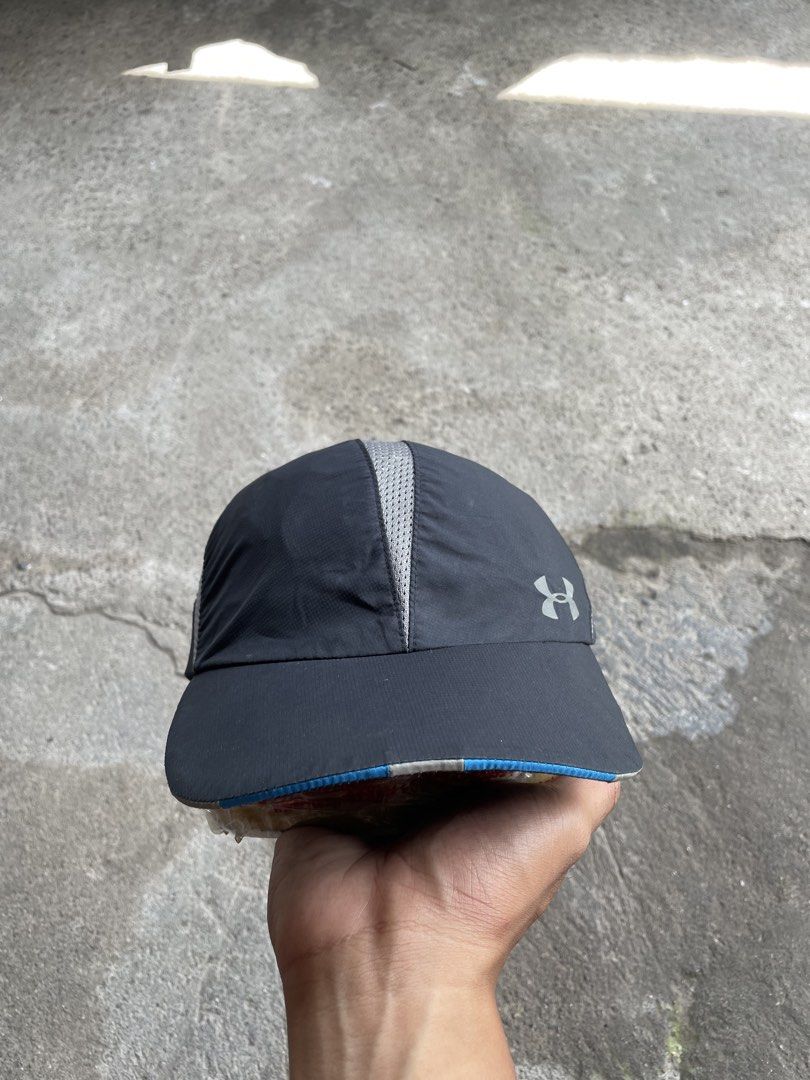 Under Armour Running Cap Black Gray (Category: Caps & Hats) located in Polomolok. Submitted by madagascarts (Listing ID 1468797049, Image 1). Description: - Brand: Under Armour - Color: Black and gray with blue accent piping on the brim - Breathable: Mesh panels on center and sides for maximum airflow - Storage: Convenient small zippered pocket on the left side panel - Visibility: Reflective logo detail on the front for low-light safety - Fit: Fu
