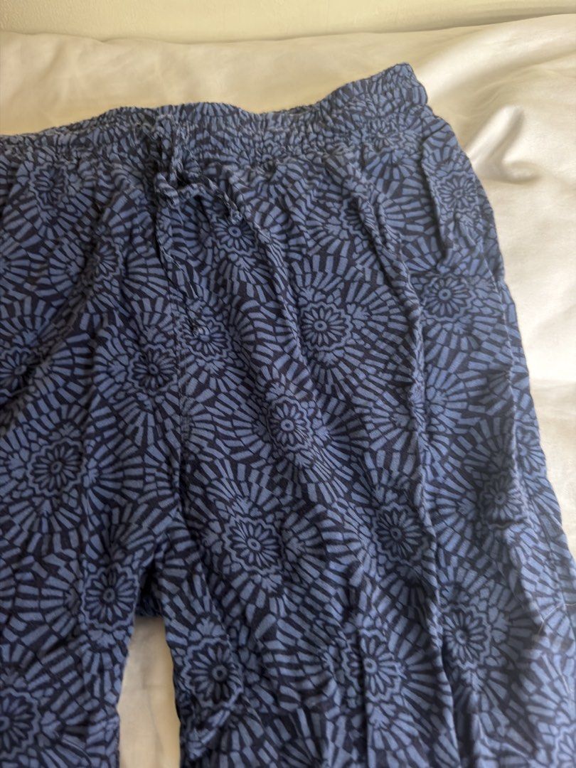 Uniqlo Blue Patterned Relaxed Pants Size S (Category: Jeans) located in Dasmarinas. Submitted by maikee0417 (Listing ID 1468763090, Image 2). Description: - Brand: Uniqlo - Style: Thin elastic pants with all-over geometric floral pattern - Color: Dark Blue - Size: S (Waist: 60-66cm, Hips: 85-91cm) - Material: 100% Rayon (lightweight & super comfortable) - Features: Elastic waistband with adjustable drawstring, cropped length (hits above the ankle