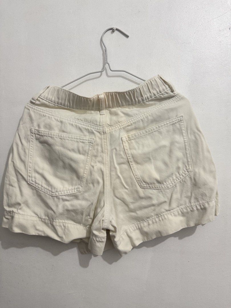 Uniqlo Drapey Denim Asymmetric Wrap Skort (Category: Skirts) located in Cainta. Submitted by selltimentalshop (Listing ID 1468920008, Image 2). Description: - Brand: Uniqlo - Style: Wrap-style skort with asymmetric front overlap and button fastening - Color: Off-White - Size: M (Fits waist 63-69cm, hips 88-94cm) - Material: 59% cotton, 41% lyocell blend; 100% cotton pocket lining - Features: Elasticated back waistband for comfort, includes side a