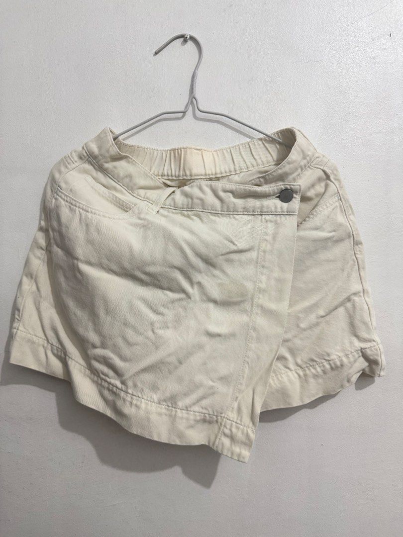 Uniqlo Drapey Denim Asymmetric Wrap Skort (Category: Skirts) located in Cainta. Submitted by selltimentalshop (Listing ID 1468920008, Image 1). Description: - Brand: Uniqlo - Style: Wrap-style skort with asymmetric front overlap and button fastening - Color: Off-White - Size: M (Fits waist 63-69cm, hips 88-94cm) - Material: 59% cotton, 41% lyocell blend; 100% cotton pocket lining - Features: Elasticated back waistband for comfort, includes side a