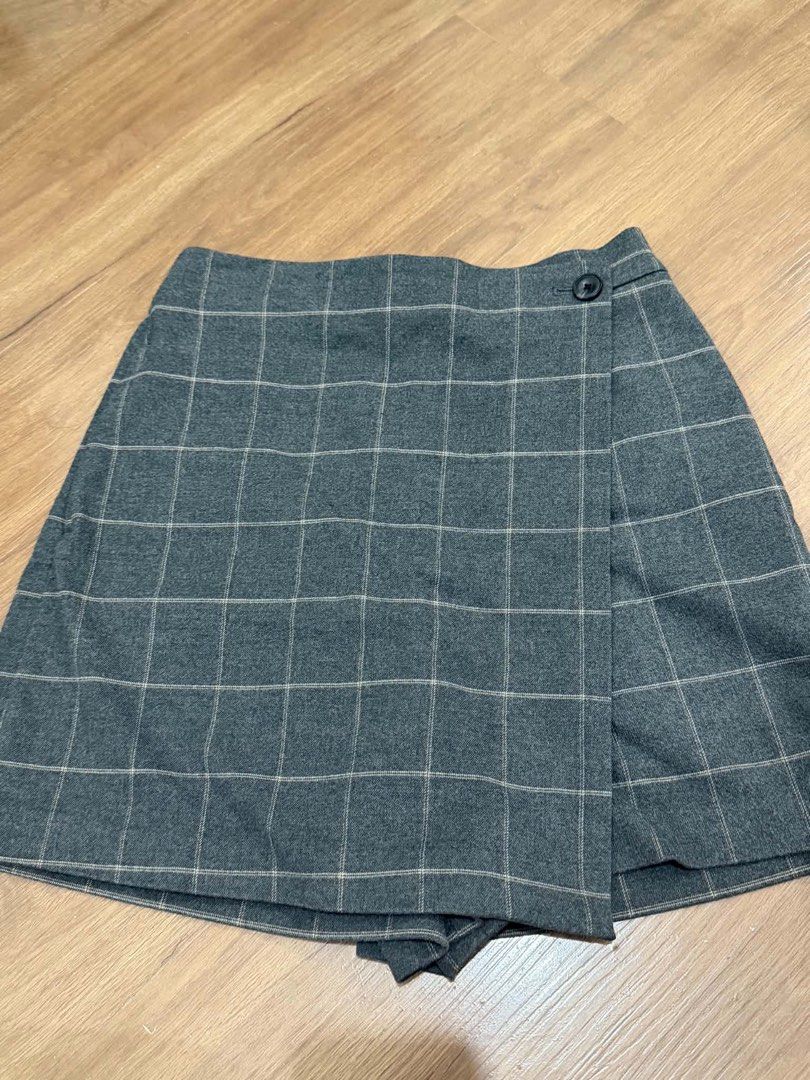 Uniqlo Grey Plaid Check Skort Size S (Category: Skirts) located in Manila. Submitted by yncldo (Listing ID 1468789503, Image 1). Description: - Brand: Uniqlo - Item: Grey plaid wrap skort with single black button closure - Size: S (Waist: 60-66cm, Hips: 85-91cm) - Material: 68% polyester, 30% rayon, 2% spandex (soft flannel-like texture) - Condition: Clean inside and out, excellent everyday wear.