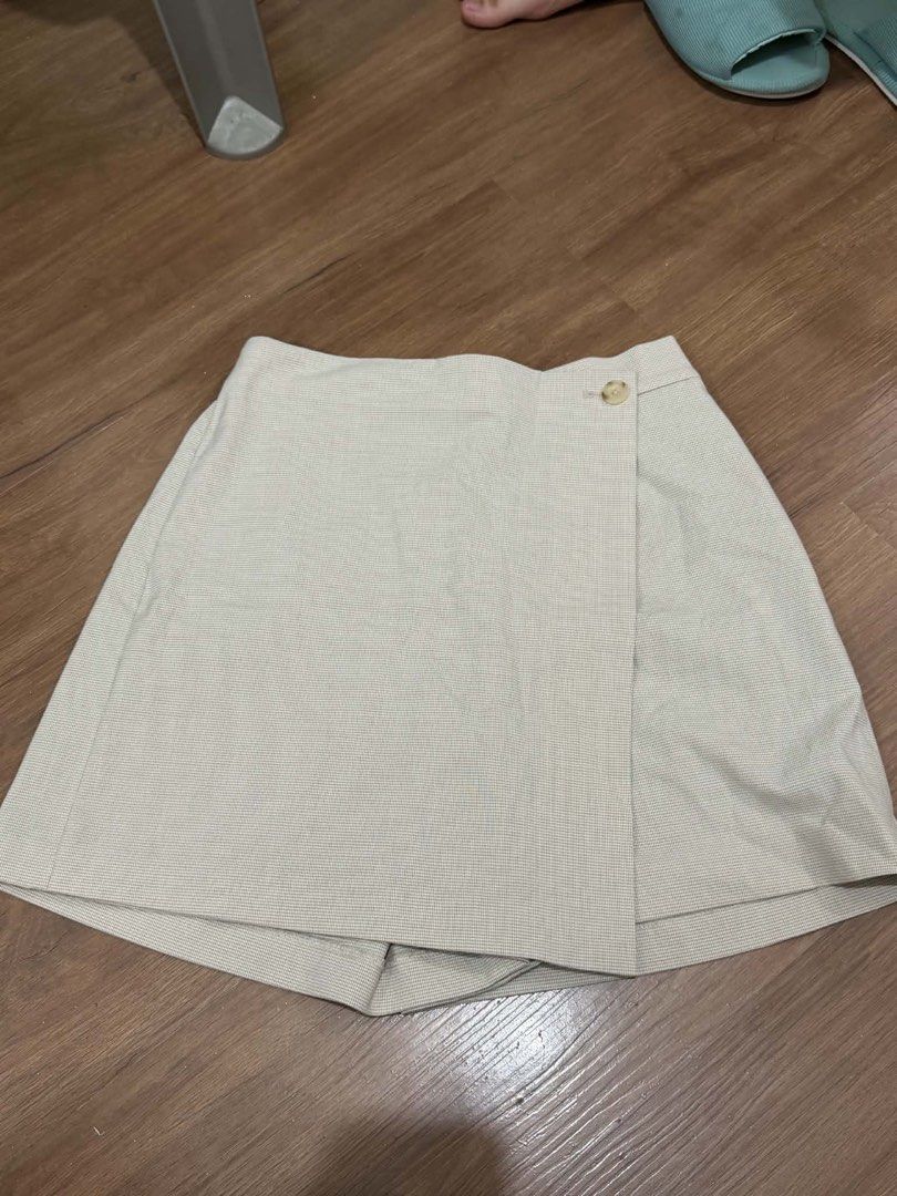 Uniqlo Houndstooth Wrap Skort Size M Beige (Category: Skirts) located in Manila. Submitted by yncldo (Listing ID 1468790966, Image 1). Description: - Brand: Uniqlo - Style: Wrap-style skort with hidden shorts lining - Pattern: Classic beige houndstooth - Size: M (Fits waist 63-69 cm, hips 88-94 cm) - Material: 66% polyester, 32% rayon, 2% spandex for a slight stretch - Details: Single button waist closure, clean inside tags - Condition: Excellent