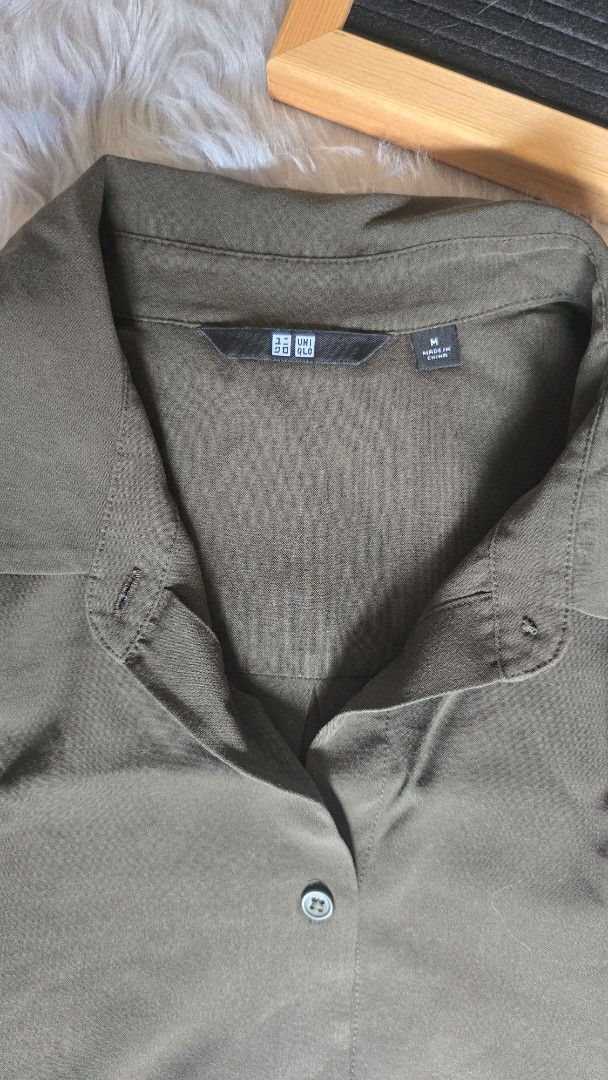 Uniqlo Olive Green Collared Button Down Shirt Medium (Category: Shirts) located in Cabanatuan. Submitted by belle_1013 (Listing ID 1468761714, Image 2). Description: - Brand: Uniqlo - Color: Olive green - Size: Medium (tag on collar) - Design: Collared neckline, front button closure, long sleeves - Fabric: Lightweight with a slight texture - Versatile: Great for layering or wearing on its own for everyday casual looks.