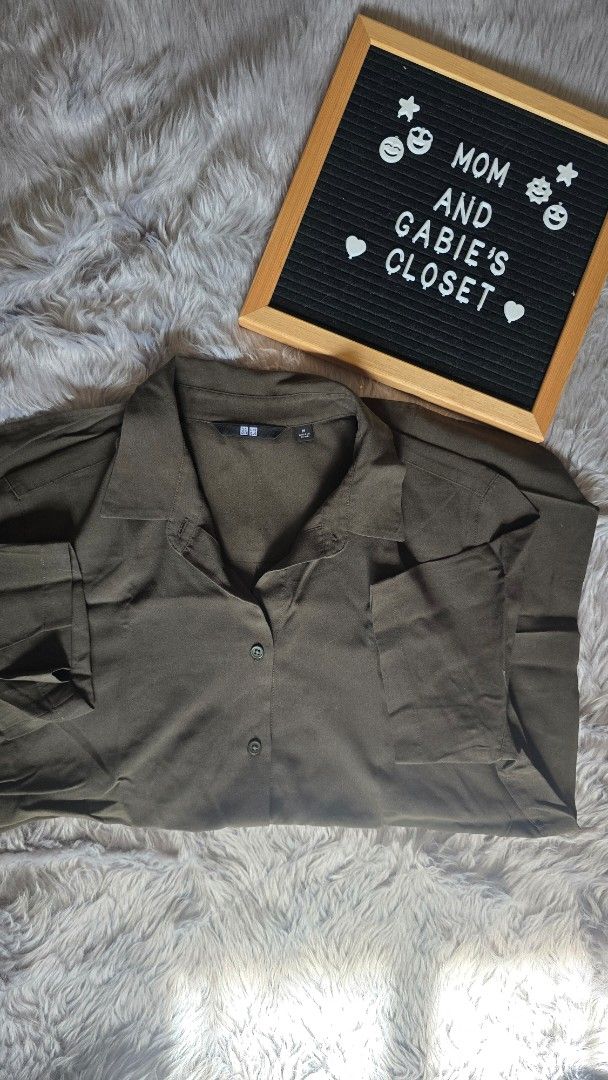 Uniqlo Olive Green Collared Button Down Shirt Medium (Category: Shirts) located in Cabanatuan. Submitted by belle_1013 (Listing ID 1468761714, Image 1). Description: - Brand: Uniqlo - Color: Olive green - Size: Medium (tag on collar) - Design: Collared neckline, front button closure, long sleeves - Fabric: Lightweight with a slight texture - Versatile: Great for layering or wearing on its own for everyday casual looks.