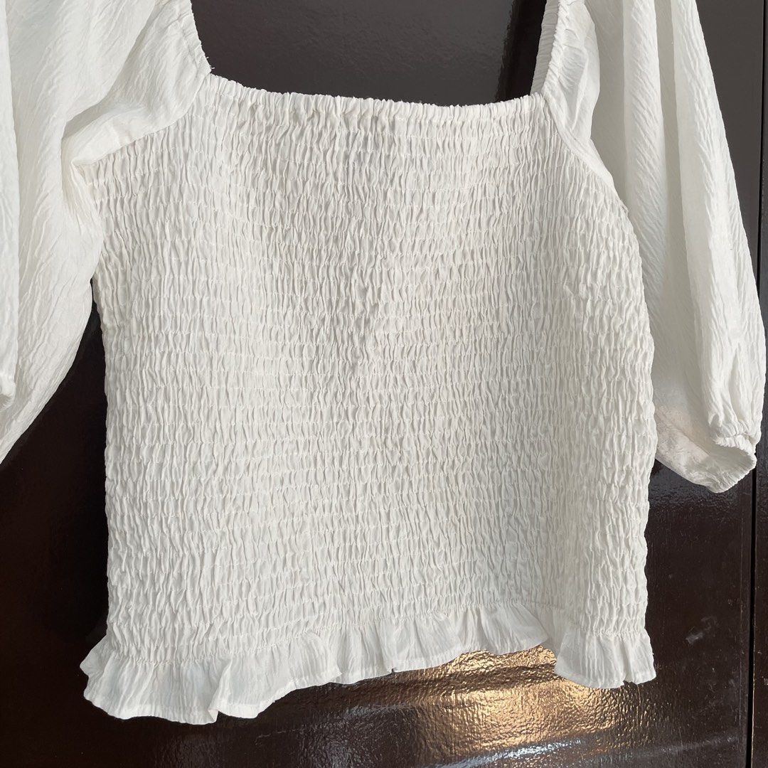 Vero Moda White Smocked Square Neck Top Size S (Category: Blouses) located in Pasay City. Submitted by lovedbyzea (Listing ID 1468783225, Image 3). Description: - Brand: Vero Moda - Color: White - Size: S (fits true) - Design: Square neckline, all-over smocked bodice, half puff sleeves with elastic cuffs, and ruffle hem - Material: Lightweight fabric (Made in India) - Styling: Perfect to pair with denim jeans or skirts.
