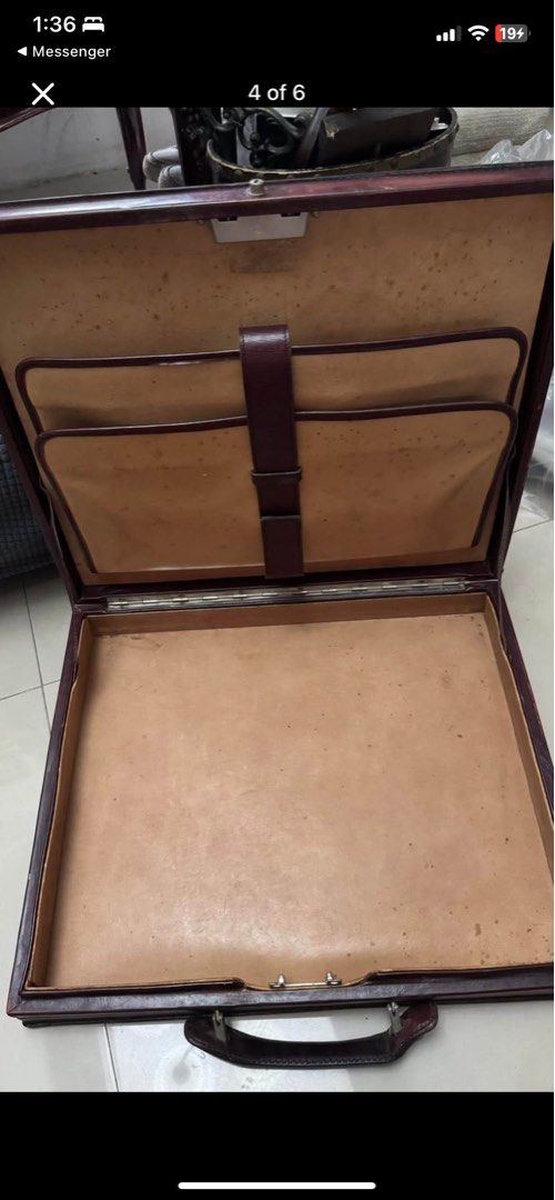 Vintage Brown Leather Briefcase Attache Case (Category: Briefcases) located in Caloocan City. Submitted by BrixGarcia (Listing ID 1468792422, Image 3). Description: - Color: Deep brown - Material: Genuine leather with tan leather lining - Features: Solid top handle, central lock closure, and divided interior document compartments with a securing strap - Condition: Visible scuffs, edge wear, and peeling on the exterior frame, along with age spots 