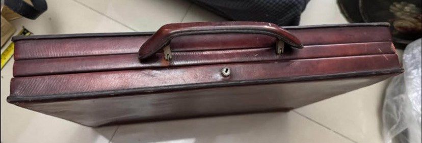 Vintage Brown Leather Briefcase Attache Case (Category: Briefcases) located in Caloocan City. Submitted by BrixGarcia (Listing ID 1468792422, Image 1). Description: - Color: Deep brown - Material: Genuine leather with tan leather lining - Features: Solid top handle, central lock closure, and divided interior document compartments with a securing strap - Condition: Visible scuffs, edge wear, and peeling on the exterior frame, along with age spots 