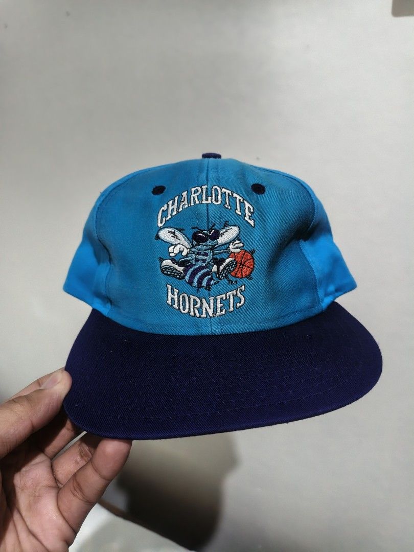 Vintage Charlotte Hornets Snapback Cap (Category: Caps & Hats) located in San Jose. Submitted by ezsenthrift475 (Listing ID 1468876783, Image 1). Description: - Official NBA licensed Charlotte Hornets snapback hat - Teal crown with dark navy brim and green underbrim - Detailed front embroidery of hornet holding a basketball - Matching 'H' logo embroidered on the back - Adjustable purple plastic snap closure - One size fits all - Made in China.