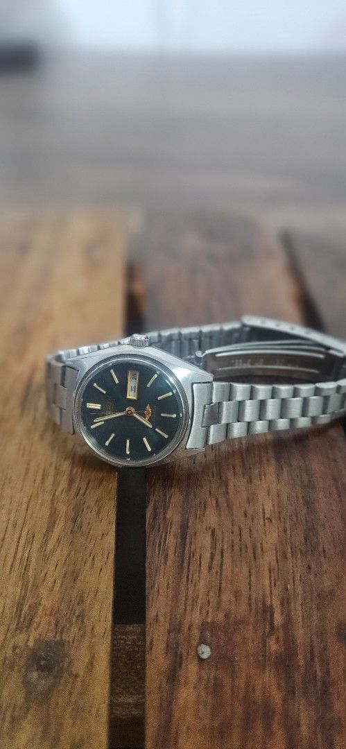 Vintage Citizen Automatic Watch (Category: Men's Watches) located in Santa Maria. Submitted by rommelmateo (Listing ID 1468861044, Image 1). Description: Vintage Citizen automatic watch with a striking dark green dial. Day and date window positioned at 3 o'clock. Stainless steel case paired with a matching metal bracelet. Acrylic crystal dome over the face. Keeps good time. Minor scuffs on the bracelet consistent with normal wear. Needs machine c