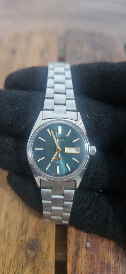 Vintage Citizen Automatic Watch (Category: Men's Watches) located in Santa Maria. Submitted by rommelmateo (Listing ID 1468861044, Image 2). Description: Vintage Citizen automatic watch with a striking dark green dial. Day and date window positioned at 3 o'clock. Stainless steel case paired with a matching metal bracelet. Acrylic crystal dome over the face. Keeps good time. Minor scuffs on the bracelet consistent with normal wear. Needs machine c