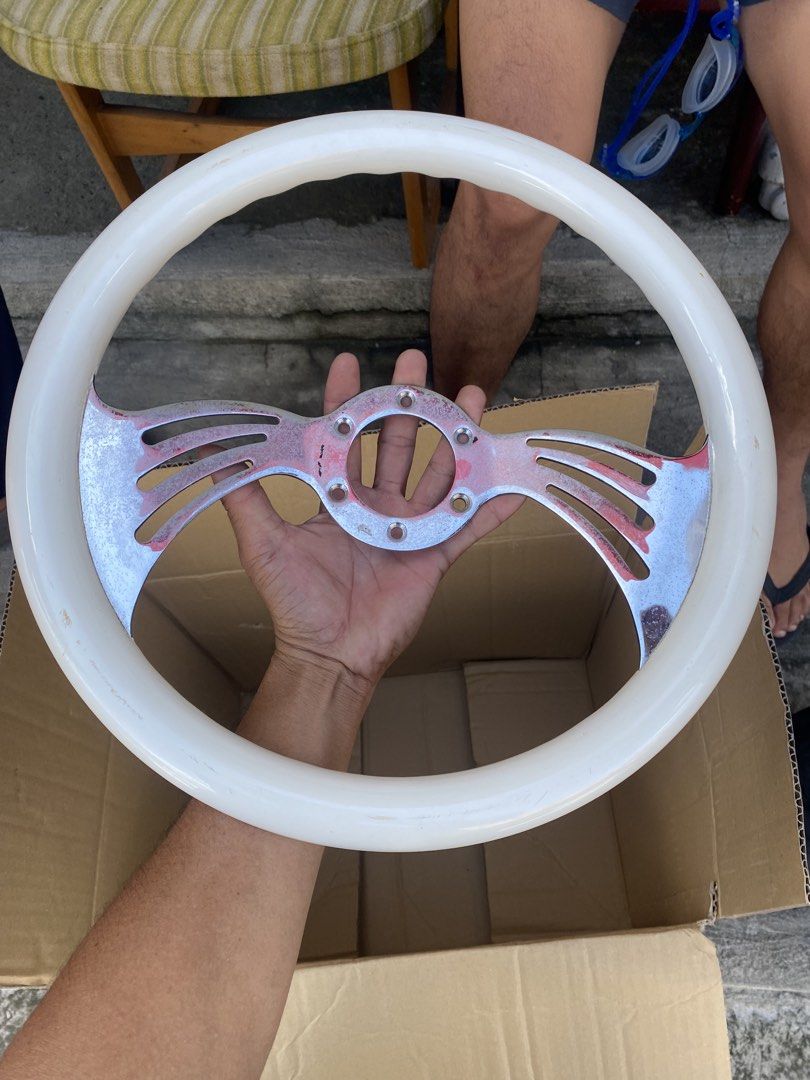 Vintage custom white and chrome steering wheel (Category: Steering, Brakes, Control Parts and Accessories) located in Tagum. Submitted by waaap420 (Listing ID 1468897182, Image 1). Description: - White grip steering wheel with stylish chrome center spokes - Features a sporty slotted spoke design on both sides - Standard multi-bolt pattern for universal compatibility - Shows minor scuffs and wear marks on the white rim and metal surface.