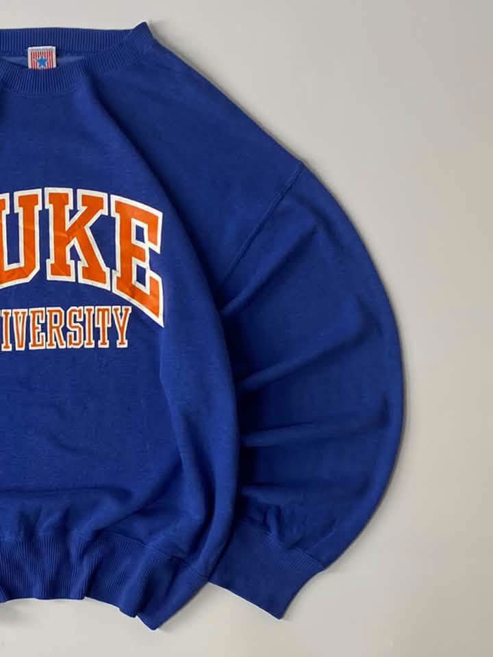 Vintage Duke University Blue Pullover Sweatshirt (Category: Coats, Jackets and Outerwear) located in Luna. Submitted by wescart (Listing ID 1468908724, Image 3). Description: width:23.5 length:26.5 Large on tag Boxy fit Color rate: 9.8/10 Issue:none VeryGood Condition.