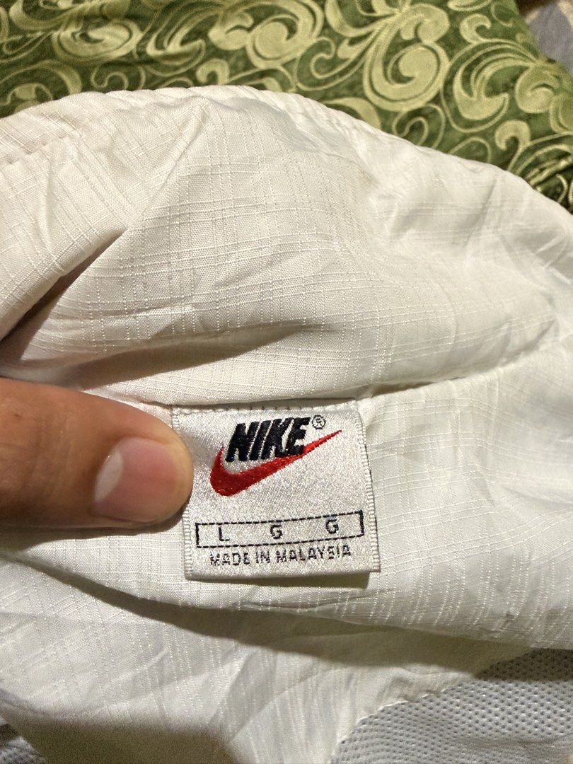 Vintage Nike White Windbreaker Jacket (Category: Coats, Jackets and Outerwear) located in Iriga City. Submitted by shoinkzz (Listing ID 1468787253, Image 2). Description: - Authentic vintage Nike windbreaker in white with dark chest and shoulder accents - Size: Large (tag inside) - Material: Durable nylon outer with breathable mesh lining - Features: Full zip front, high collar, and two front pockets - Details: Iconic Nike branding on the sleeve 