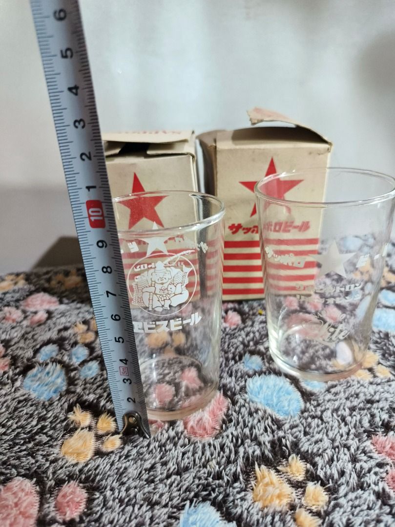 Vintage Sapporo Beer Glasses with Original Boxes (Category: Vintage Collectibles) located in San Leonardo. Submitted by burgossanleonardo.12345 (Listing ID 1468764863, Image 2). Description: - Set of 2 vintage Sapporo beer glasses - Features unique graphic prints: one with the Ebisu deity logo and Japanese text, the other with a star emblem and Sapporo Lite branding - Height: Approx. 11 cm - Includes original cardboard packaging boxes with red st