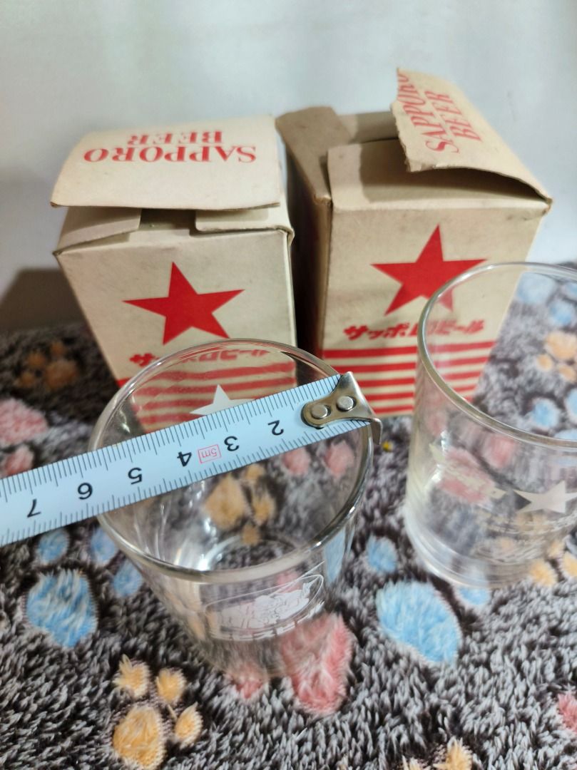 Vintage Sapporo Beer Glasses with Original Boxes (Category: Vintage Collectibles) located in San Leonardo. Submitted by burgossanleonardo.12345 (Listing ID 1468764863, Image 3). Description: - Set of 2 vintage Sapporo beer glasses - Features unique graphic prints: one with the Ebisu deity logo and Japanese text, the other with a star emblem and Sapporo Lite branding - Height: Approx. 11 cm - Includes original cardboard packaging boxes with red st