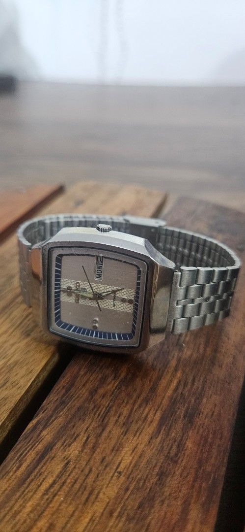 Vintage Seiko 5 Automatic Square Dial Watch (Category: Men's Watches) located in Santa Maria. Submitted by rommelmateo (Listing ID 1468861494, Image 2). Description: - Brand/Model: Seiko 5 Automatic - Case: Square silver case with minimal signs of wear - Dial: Textured grey dial with a clean crystal - Features: Day and date window, and crown uniquely positioned at the 9 o'clock mark - Bracelet: Stainless steel stretch bracelet - Condition: Keeps 