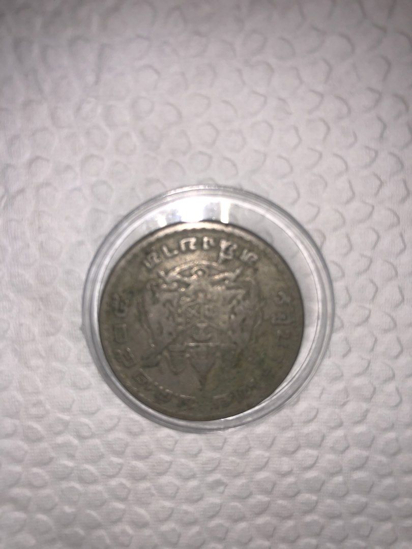 Vintage silver coin in protective capsule (Category: Currency) located in Muntinlupa City. Submitted by jkani (Listing ID 1468754578, Image 2). Description: - Vintage commemorative coin with a detailed portrait on the front and an intricate crest on the reverse - Housed securely inside a clear plastic protective capsule - Displays natural tarnish and authentic patina that adds to its vintage character - Clear and well-preserved details along the 