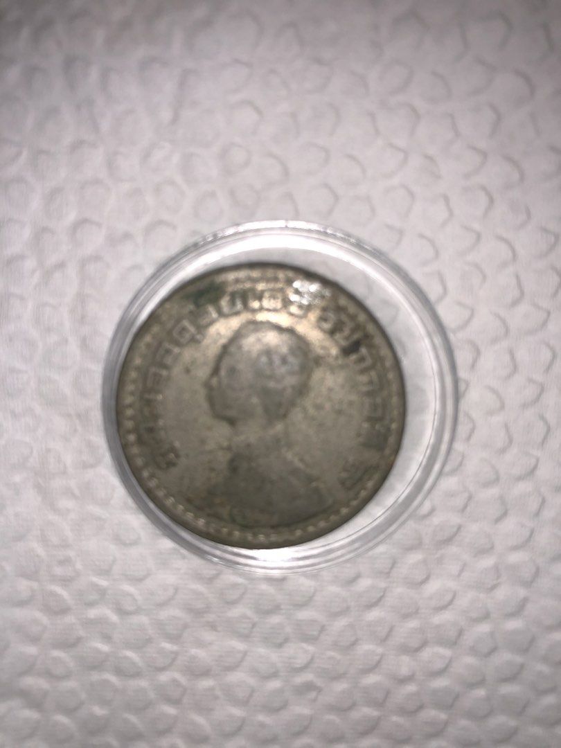 Vintage silver coin in protective capsule (Category: Currency) located in Muntinlupa City. Submitted by jkani (Listing ID 1468754578, Image 1). Description: - Vintage commemorative coin with a detailed portrait on the front and an intricate crest on the reverse - Housed securely inside a clear plastic protective capsule - Displays natural tarnish and authentic patina that adds to its vintage character - Clear and well-preserved details along the 