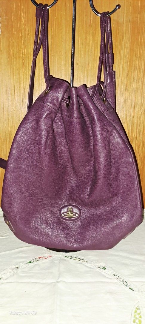 Vivienne Westwood drawstring leather bucket backpack orb logo (Category: Backpacks) located in Baguio. Submitted by mng_assorted_baguio (Listing ID 1468836224, Image 1). Description: - Brand: Vivienne Westwood - Color: Deep Purple - Material: Supple pebbled leather with contrasting dark stitching - Hardware: Antiqued gold-tone - Closure: Drawstring with adjustable shoulder straps - Features: Distinctive metallic orb logo on the front and roomy in