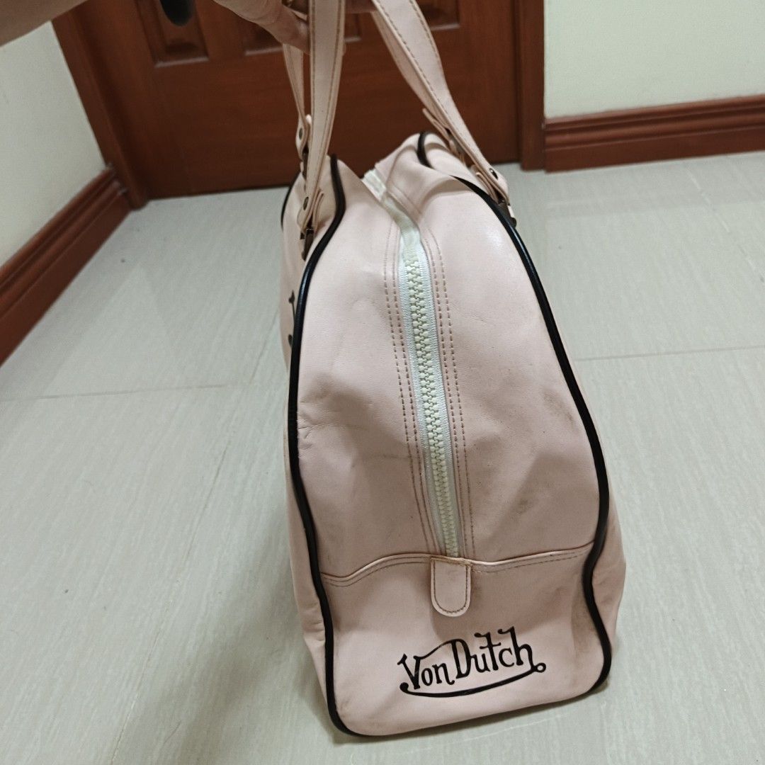 Von Dutch Pink Bowling Bag (Category: Shoulder Bags) located in Nasugbu. Submitted by staffpicks1515 (Listing ID 1468785803, Image 2). Description: - Brand: Von Dutch - Color: Pink with black branding - Style: Bowling bag with double top handles - Details: Chunky white zipper, protective metal feet, pink lining with logo patch - Condition: Minor signs of use, slight print fade, and some washable dirt.