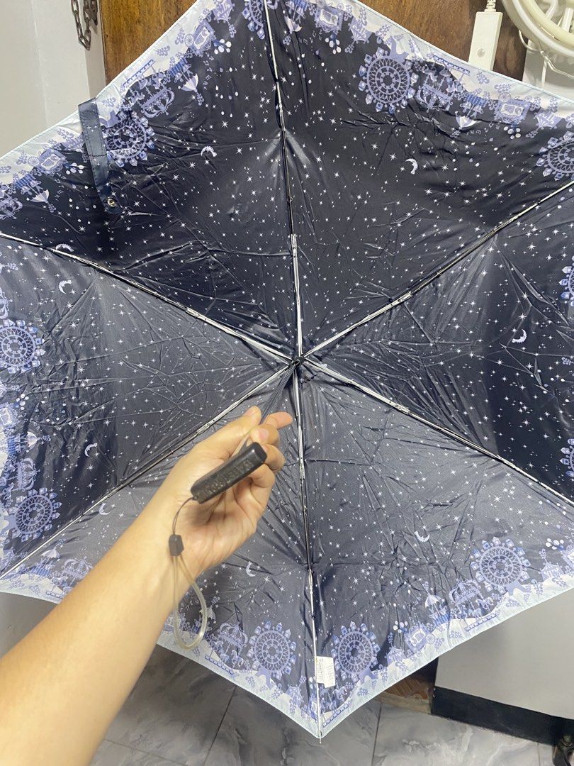 Waterfront Foldable Umbrella Navy Blue Starry Night Pattern (Category: Umbrellas) located in Pasacao. Submitted by wengpullar37205 (Listing ID 1468786297, Image 3). Description: - Brand/Model: Waterfront compact folding umbrella - Design: Navy blue canopy with cute white stars, moons, and decorative border - Portability: Handy size, easy to toss into a tote bag or backpack - Features: Manual open/close mechanism, flat black handle with attached w