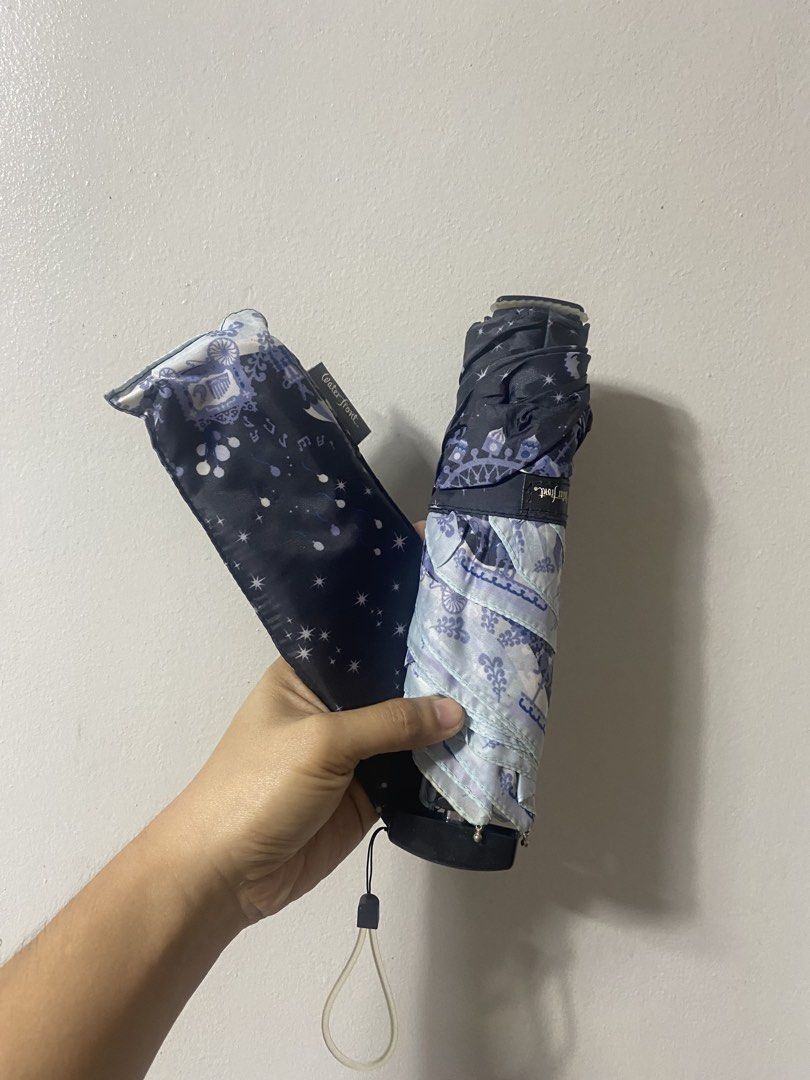 Waterfront Foldable Umbrella Navy Blue Starry Night Pattern (Category: Umbrellas) located in Pasacao. Submitted by wengpullar37205 (Listing ID 1468786297, Image 1). Description: - Brand/Model: Waterfront compact folding umbrella - Design: Navy blue canopy with cute white stars, moons, and decorative border - Portability: Handy size, easy to toss into a tote bag or backpack - Features: Manual open/close mechanism, flat black handle with attached w