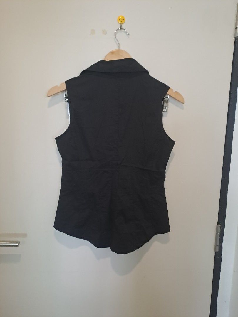 WHBM SLEEVELESS NEW (Category: Undergarments & Loungewear) located in Manila. Submitted by joanbalde39643 (Listing ID 1468754106, Image 3). Description: The item shown is a black sleeveless collared button-down blouse featuring distinct pleated/ruched vertical detailing down the center placket. It has a structured spread collar, a contoured princess-cut silhouette, and curved hem detailing..