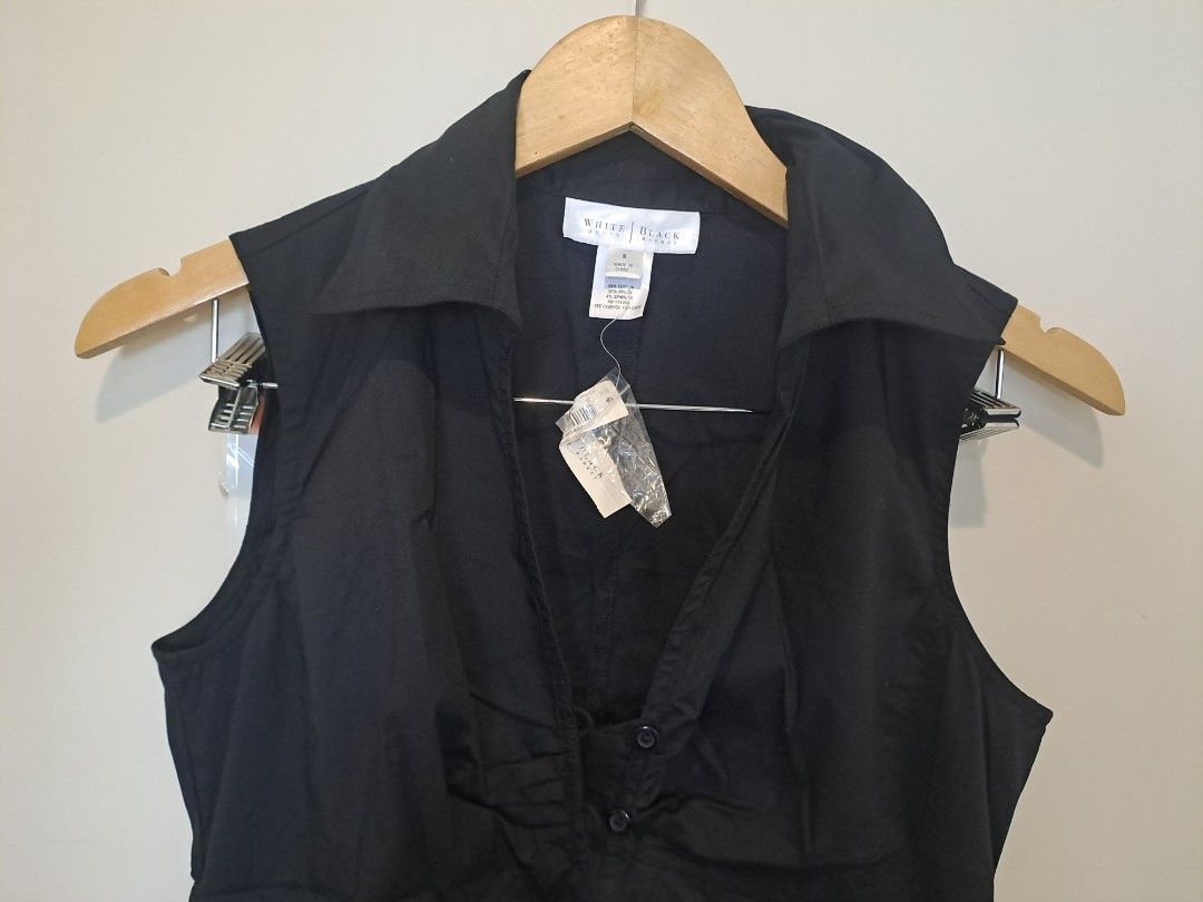 WHBM SLEEVELESS NEW (Category: Undergarments & Loungewear) located in Manila. Submitted by joanbalde39643 (Listing ID 1468754106, Image 2). Description: The item shown is a black sleeveless collared button-down blouse featuring distinct pleated/ruched vertical detailing down the center placket. It has a structured spread collar, a contoured princess-cut silhouette, and curved hem detailing..