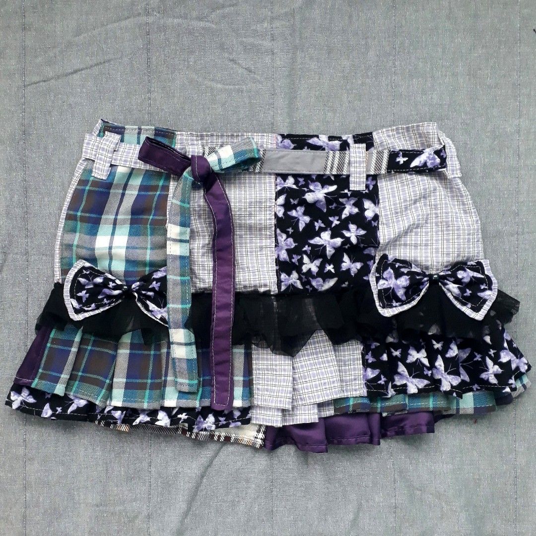 Whimsigoth Patchwork Pleated Mini Skirt (Category: Skirts) located in Cabanatuan. Submitted by madeby_csnstudio (Listing ID 1468729281, Image 1). Description: MEASUREMENTS: Waist: 30 inches (76.2 cm) Hips: 37 inches (93.98 cm) Length: 13 inches (33.02 cm) DETAILS: Constructed from a mix of multi-fabric patchwork panels, the skirt features a contrasting combination of cool-toned blue and grey plaid alongside purple butterfly print sections. Adding