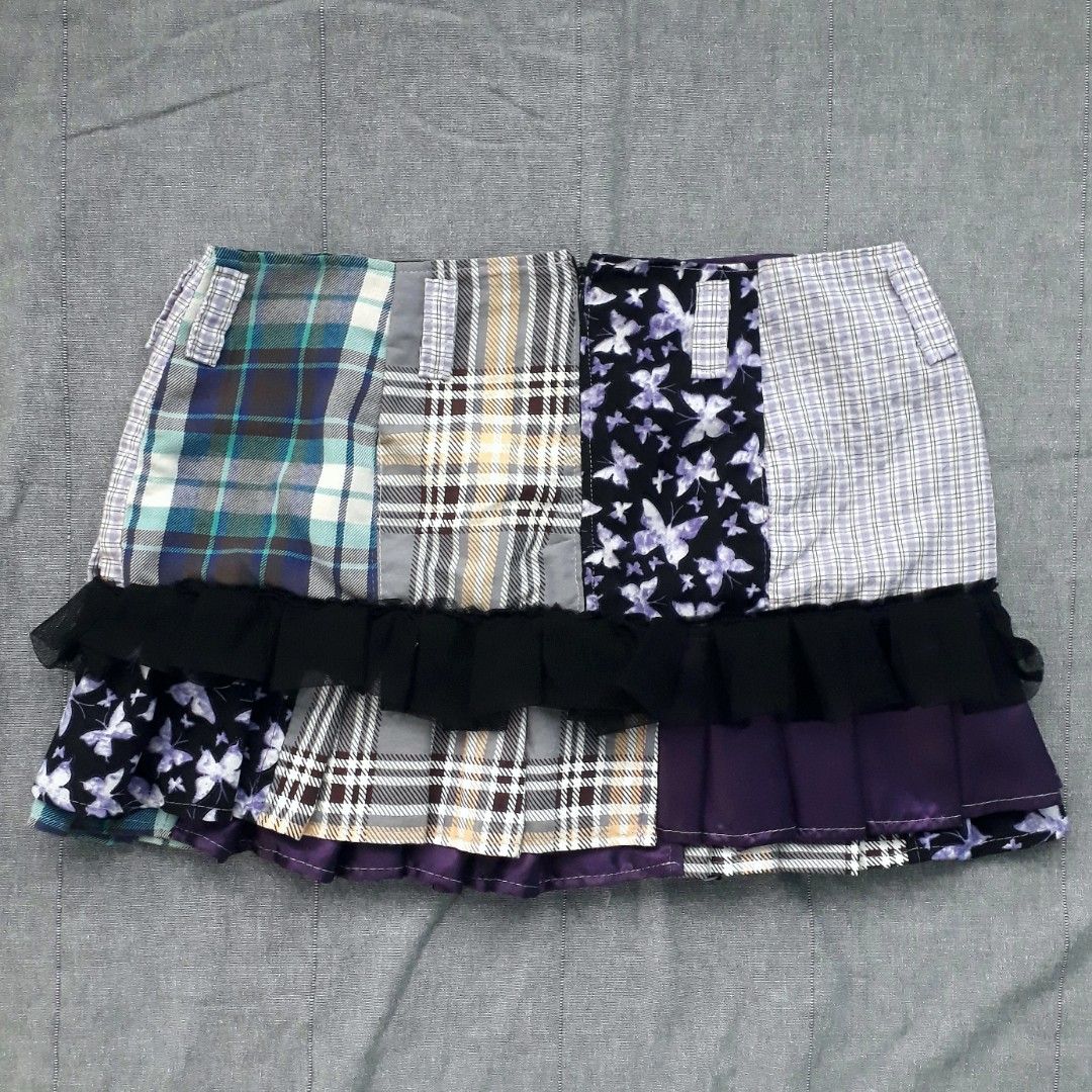 Whimsigoth Patchwork Pleated Mini Skirt (Category: Skirts) located in Cabanatuan. Submitted by madeby_csnstudio (Listing ID 1468729281, Image 3). Description: MEASUREMENTS: Waist: 30 inches (76.2 cm) Hips: 37 inches (93.98 cm) Length: 13 inches (33.02 cm) DETAILS: Constructed from a mix of multi-fabric patchwork panels, the skirt features a contrasting combination of cool-toned blue and grey plaid alongside purple butterfly print sections. Adding