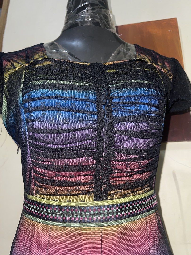 Whimsy Rainbow Mesh Sequin Dress with Rose Applique (Category: Dresses) located in La Trinidad. Submitted by potatothriftlip (Listing ID 1468828031, Image 2). Description: - Vibrant multi-color rainbow gradient mesh dress - Elegant black lace cap sleeves and pleated flared skirt - Lower skirt features striking pink rose appliques and scattered gold sequins - Detailed patterned waistband with a ruffled button placket down the front - Convenient si