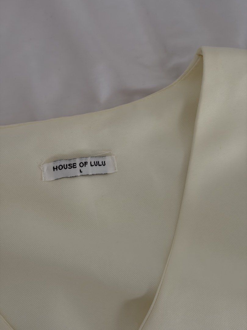 White / Cream Vest Size L (Category: Sleeveless) located in Las Pinas. Submitted by thriftedfinds_ (Listing ID 1468868324, Image 2). Description: - Brand: House of Lulu - Color: Cream - Size: Large - V-neck design with 4 front buttons - Tailored seams for a flattering fit - Adjustable back strap with metal buckle - Clean fabric throughout.