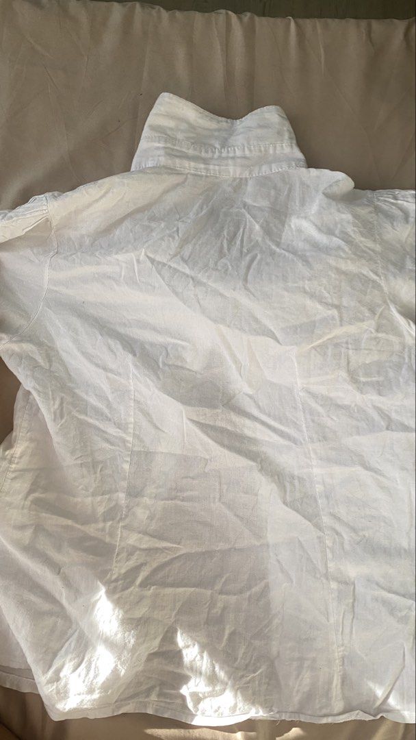 White button-up short sleeve blouse with ruffles (Category: Blouses) located in Manila. Submitted by rumyewn (Listing ID 1468790249, Image 2). Description: - Color/Style: White short-sleeve button-down shirt - Design: Classic collar, delicate pleated panels, and ruffled front placket trim - Details: Short sleeves with small button tabs on cuffs - Fit & Fabric: Lightweight material with a tailored fit - Condition: Needs ironing & button replacemen