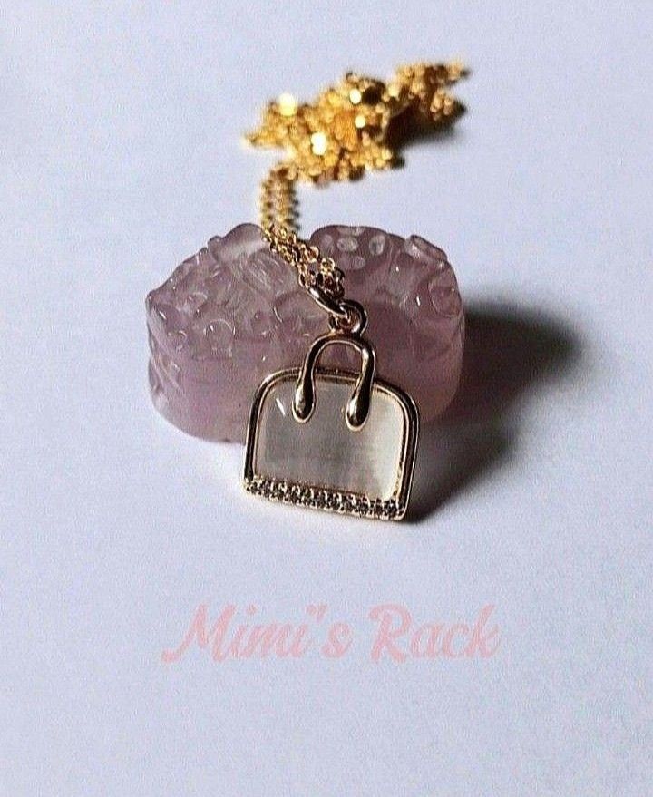 WHITE CAT'S EYE BAG NECKLACE (Category: Necklaces) located in Taguig. Submitted by mimisrack (Listing ID 1468922647, Image 2). Description: 🤍Cute... but lucky. Charm and protection -Bag symbol for wealth and savings -Gold setting for classy glow -Perfect for everyday glam with a touch of prosperity luck -Sweet look. Strong meaning. 🧿 needle chain: approx. 44cm (17in) 🧿 pendant size: 13mm ▪️keep jewelries separated to avoid scratching. ▪️the je