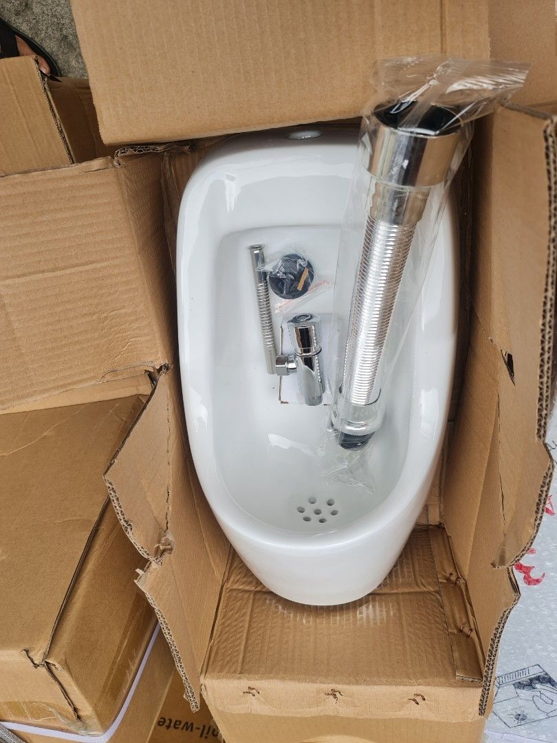 White Ceramic Urinal with Plumbing Hardware Box Set (Category: Bathroom & Kitchen Fixtures) located in Manila. Submitted by oddcrystal_66a000 (Listing ID 1468820939, Image 2). Description: - Brand new white ceramic wall-hung urinal bowl in original box - Complete box set with all necessary parts included - Comes with metal flush pipe, connectors, and mounting hardware - Includes unused plumbing fixtures stored inside the bowl - Factory-wrapped pa